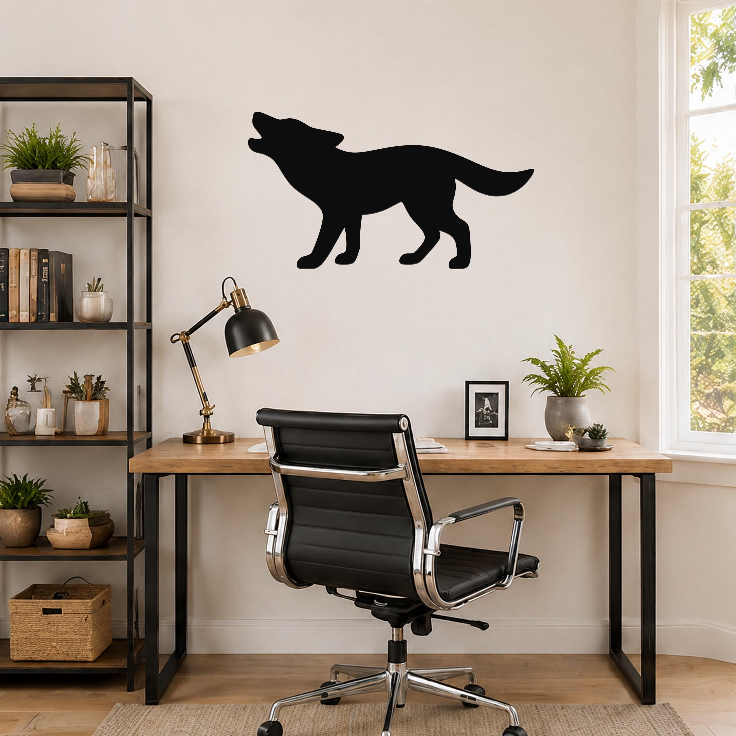 Black metal coyote wall art in a howling silhouette, mounted on a wall above a wooden desk in a home office.