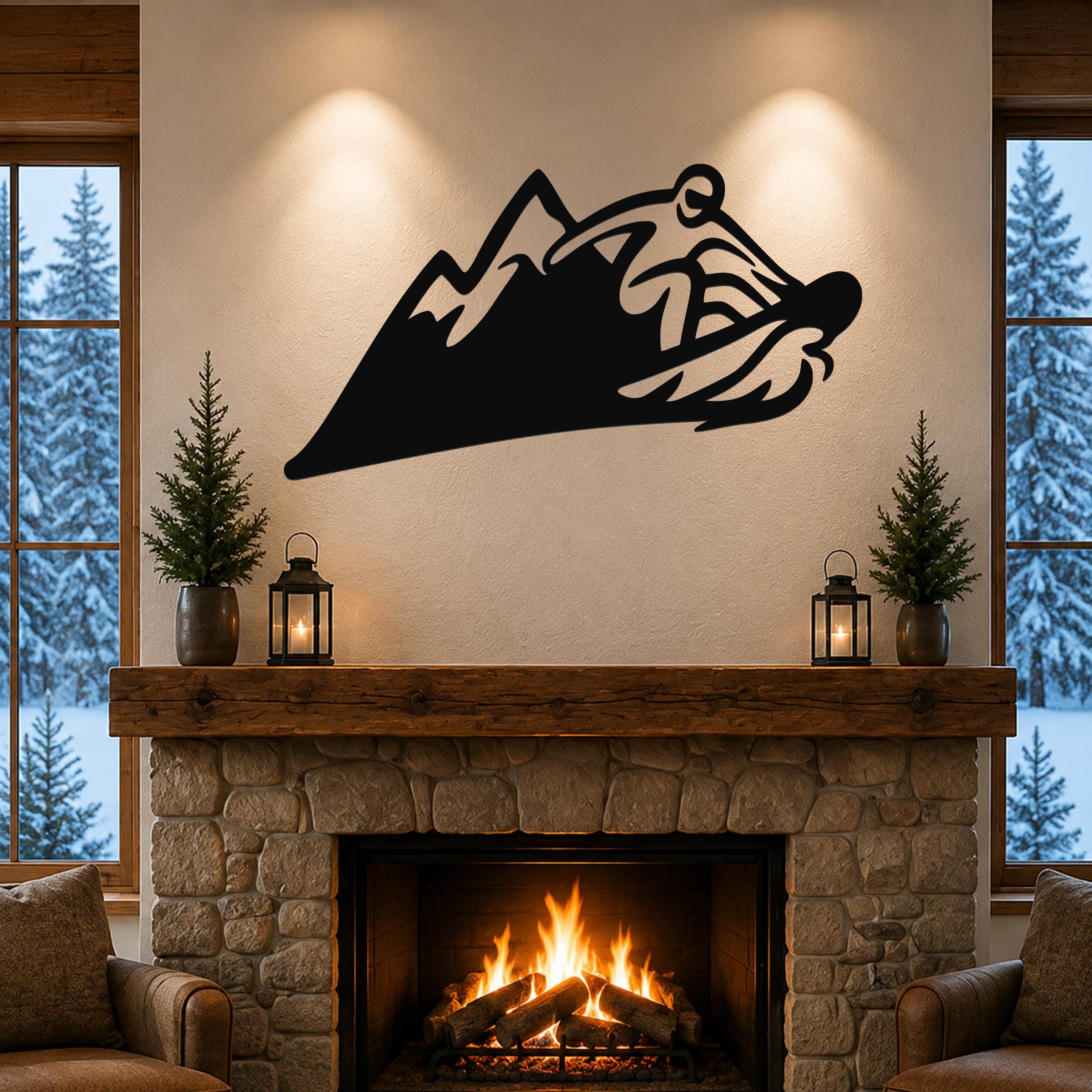 Black metal wall art with a snowboarder silhouette cutout, mounted above a stone fireplace in a living room.