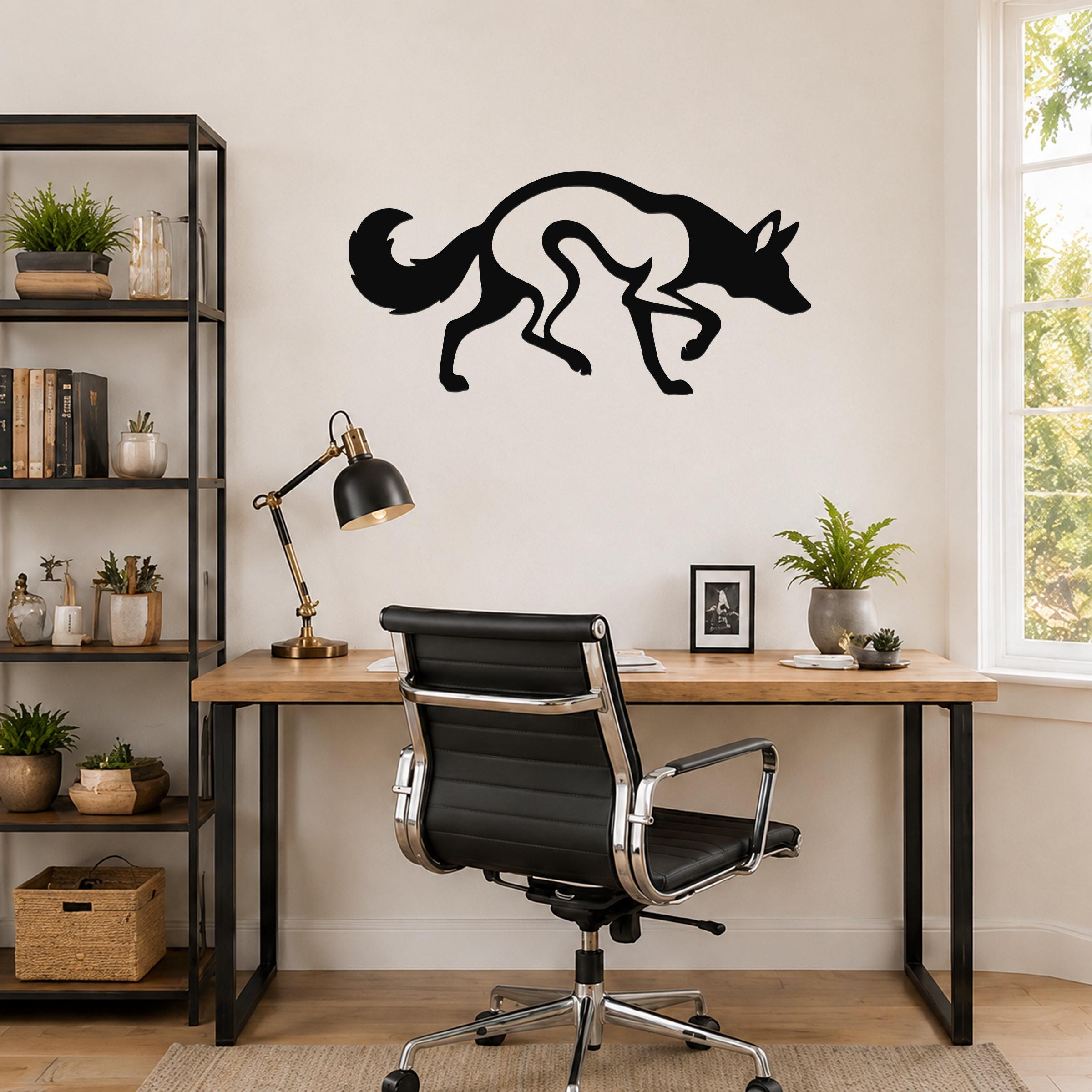 Black metal coyote wall art with a cutout silhouette design, mounted on a wall above a wooden desk in a home office.