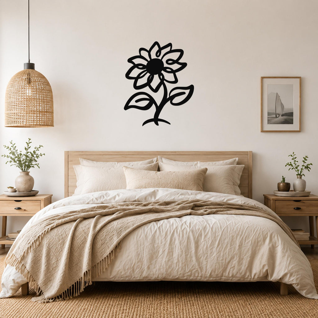 Black metal sunflower wall art with cutout petals and leaves, mounted above a wooden bed in a neutral bedroom.