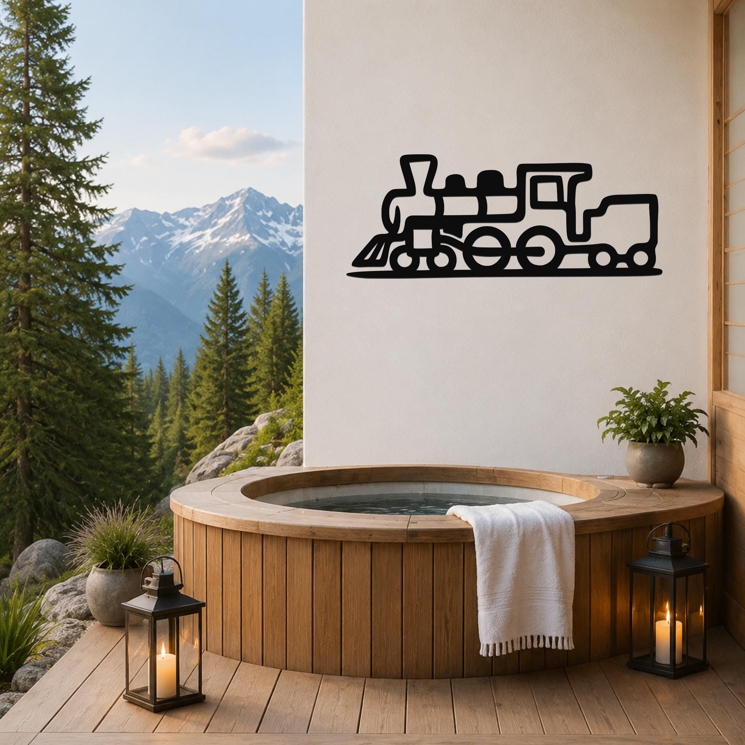 Black metal train silhouette wall art mounted on a white wall above a wooden hot tub on a mountain-view deck.
