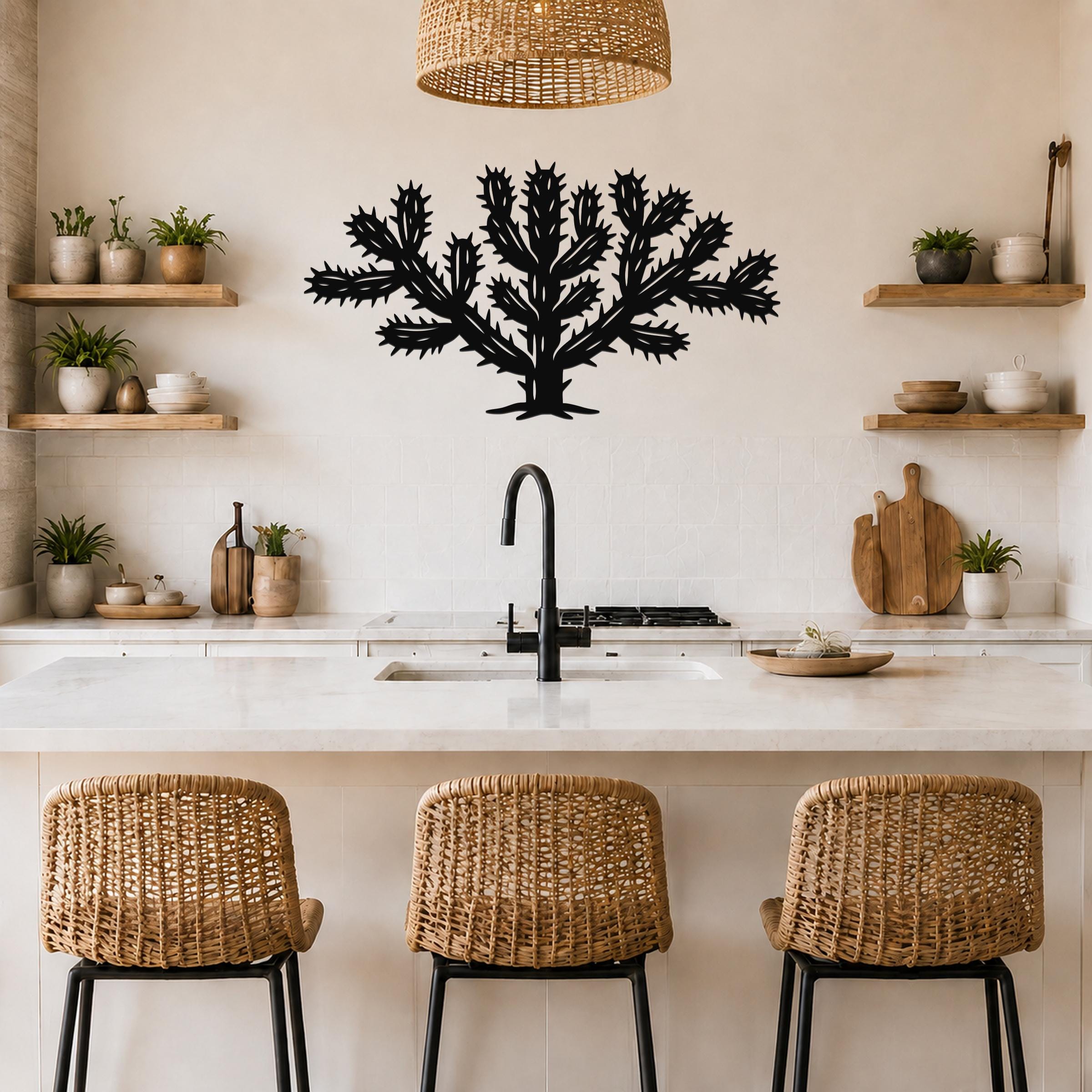 Black metal Cholla cactus wall art with spiky branch cutouts, mounted on a kitchen wall above a counter.