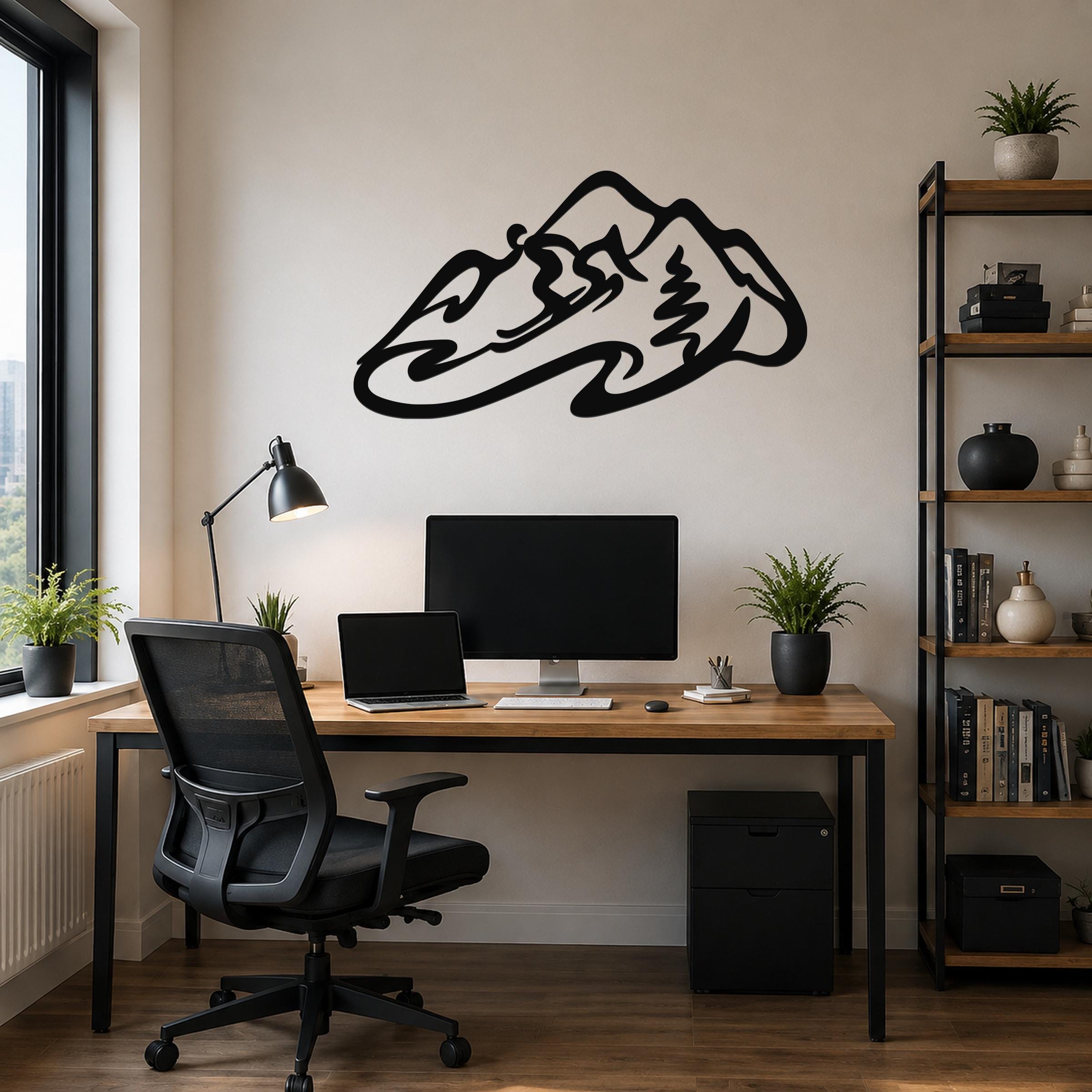 Black metal wall art in a minimalist skier silhouette design, mounted above a wooden desk in a home office.