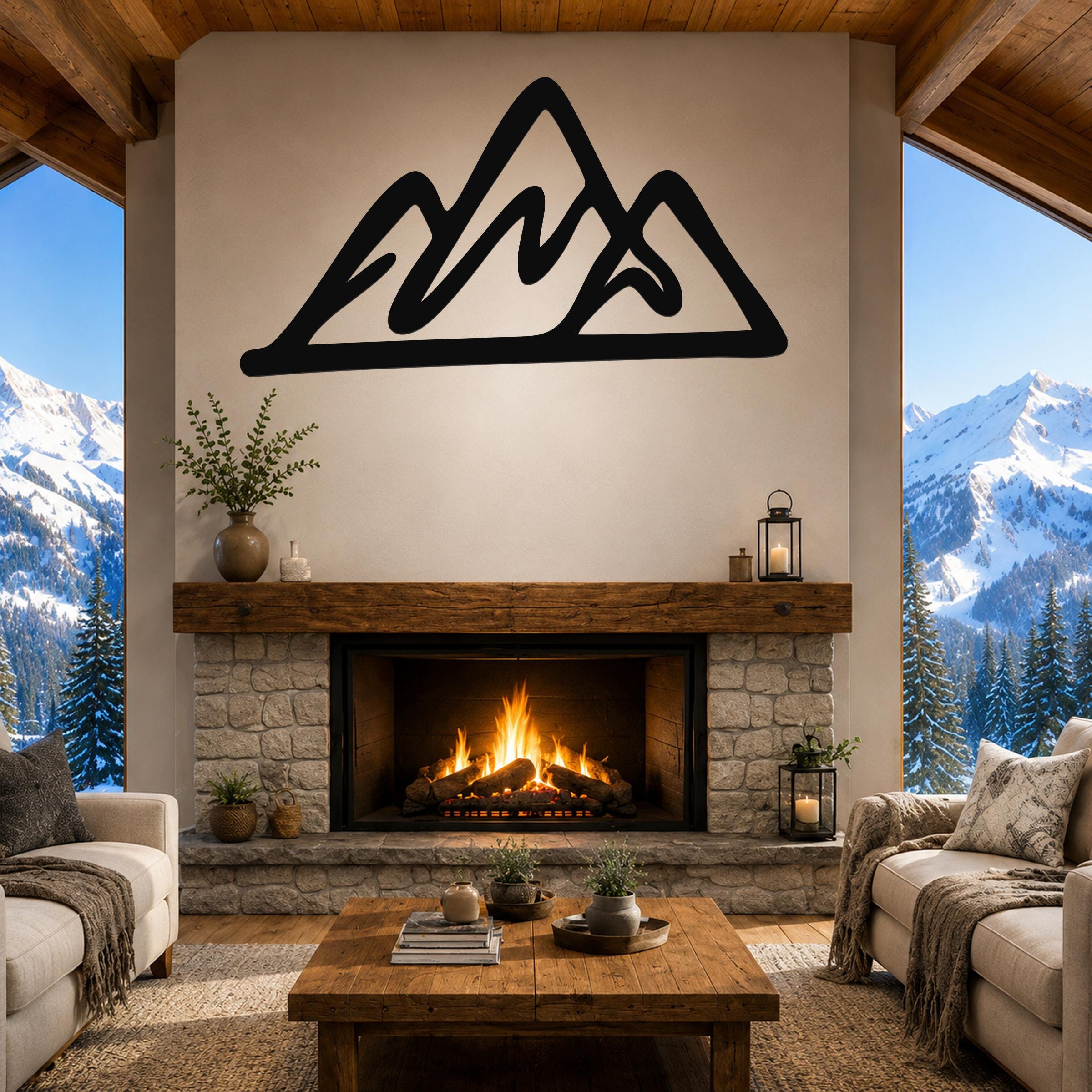 Black metal mountain silhouette wall art mounted above a stone fireplace in a rustic living room with large windows showing snowy peaks.