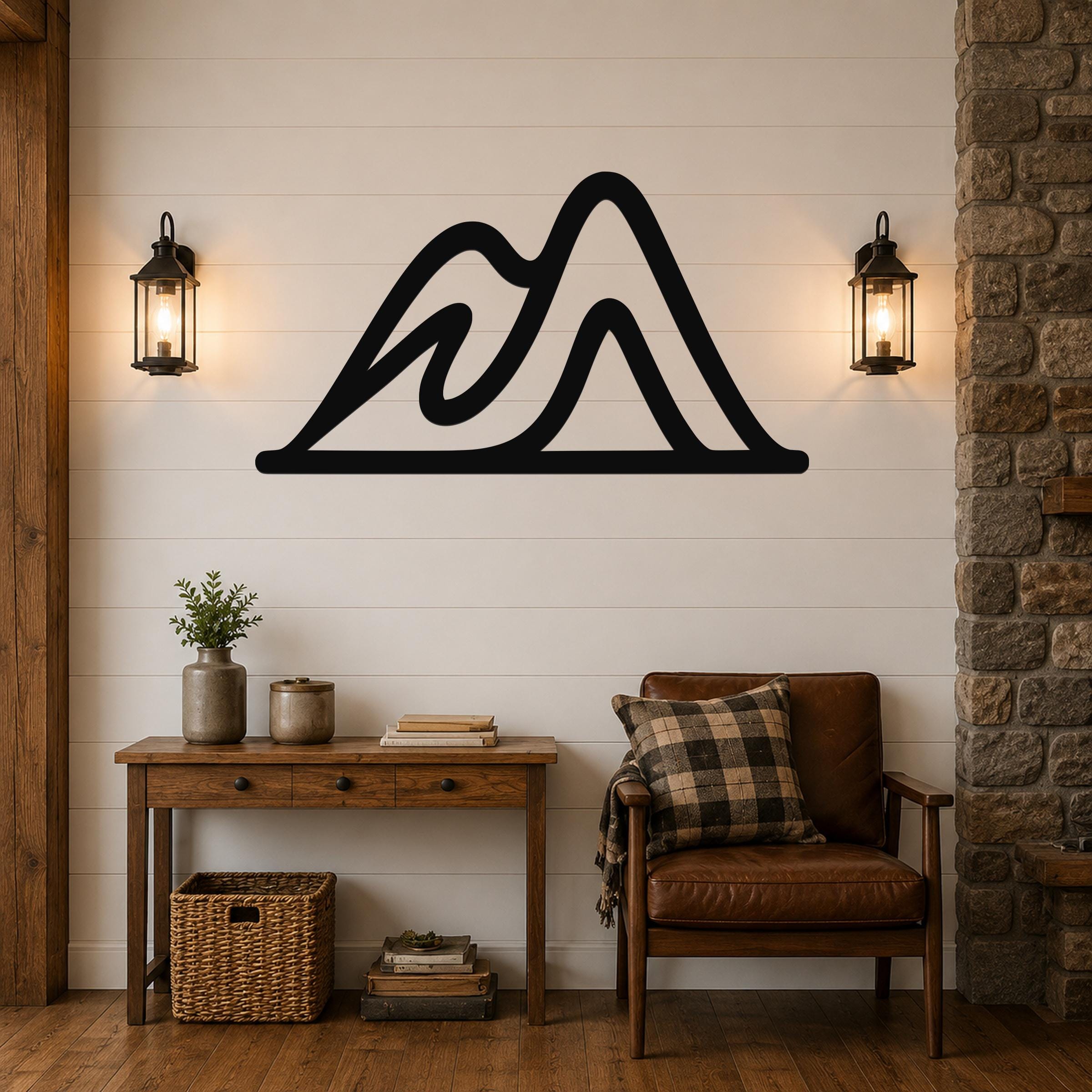 Black metal mountain silhouette wall art with layered peaks, mounted on a shiplap wall above a wooden console table in a rustic living room.