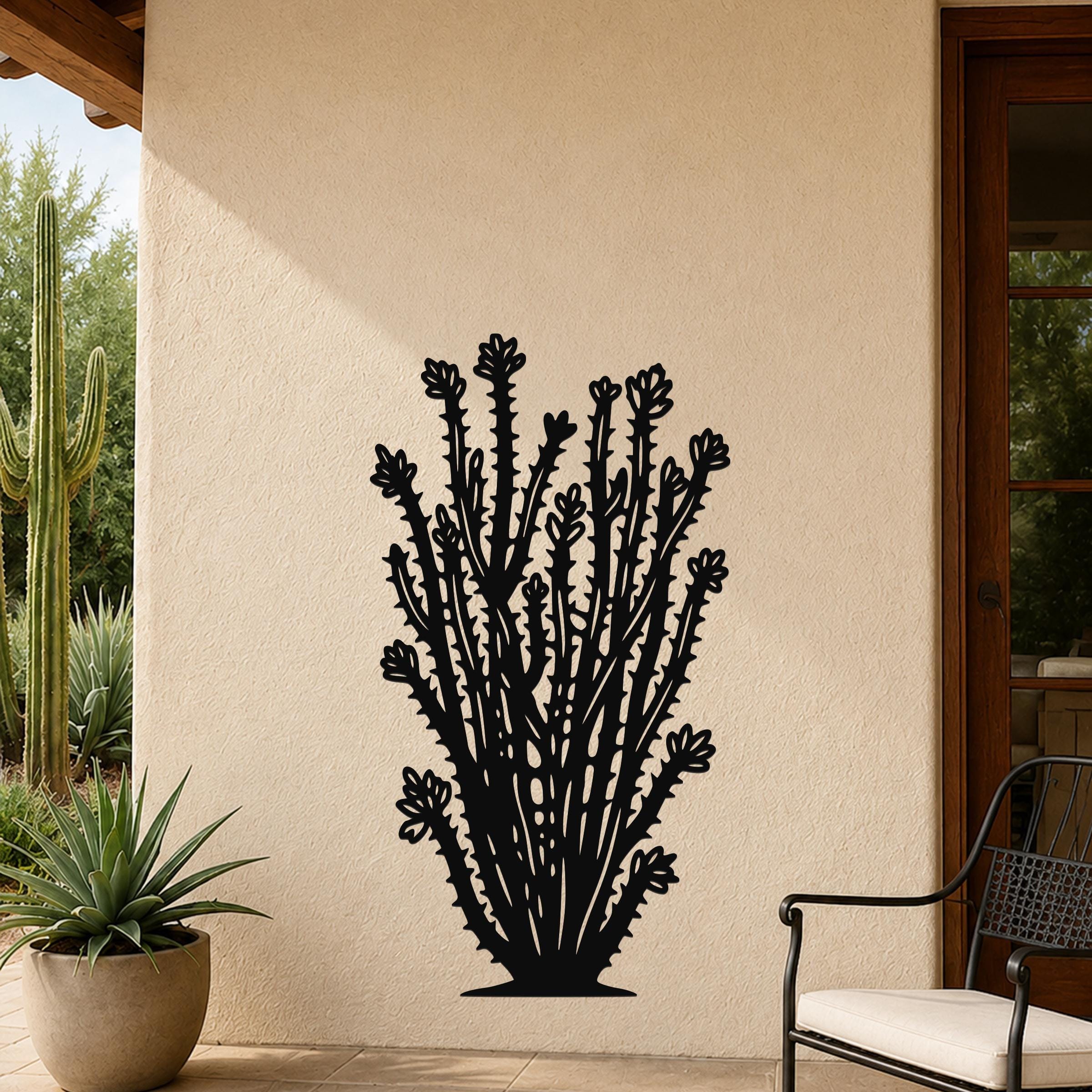 Black metal ocotillo wall art with detailed branch and flower cutouts, mounted on an outdoor patio wall beside a potted plant and chair.