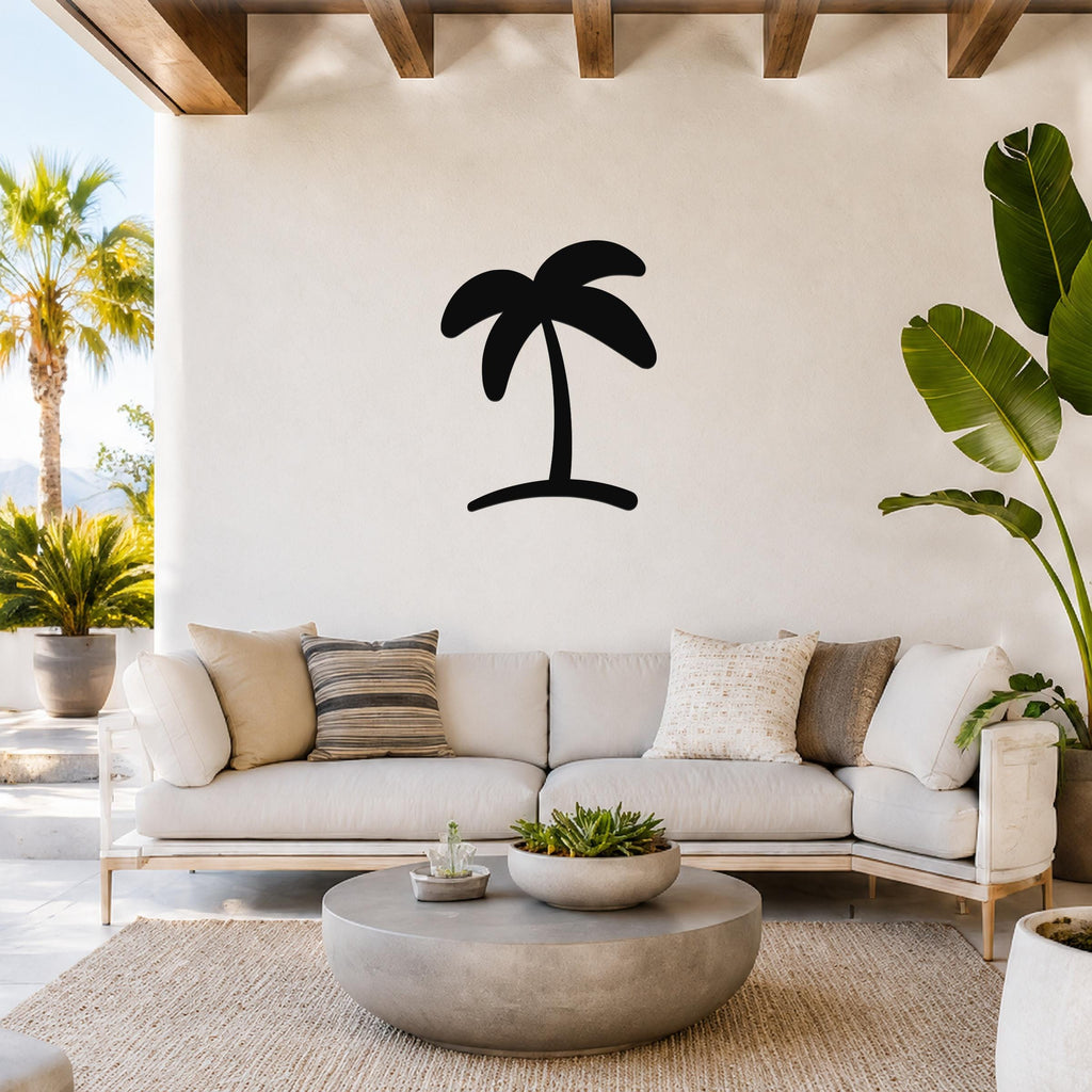 Black metal palm tree wall art silhouette mounted on a white wall above a light-colored sofa in a bright living room.
