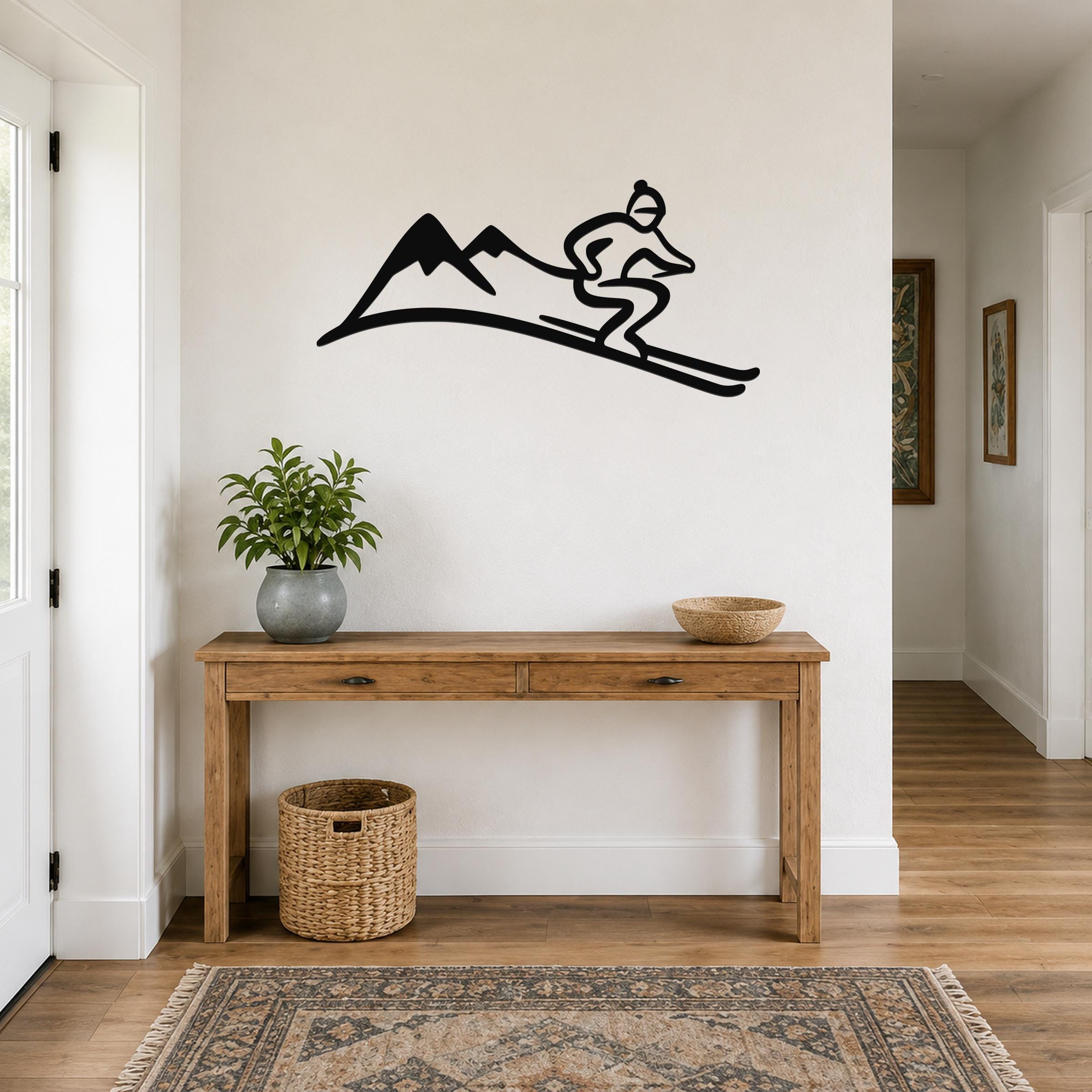 Black metal wall art featuring a skier silhouette on a mountain slope, mounted above a wooden console table in a hallway.