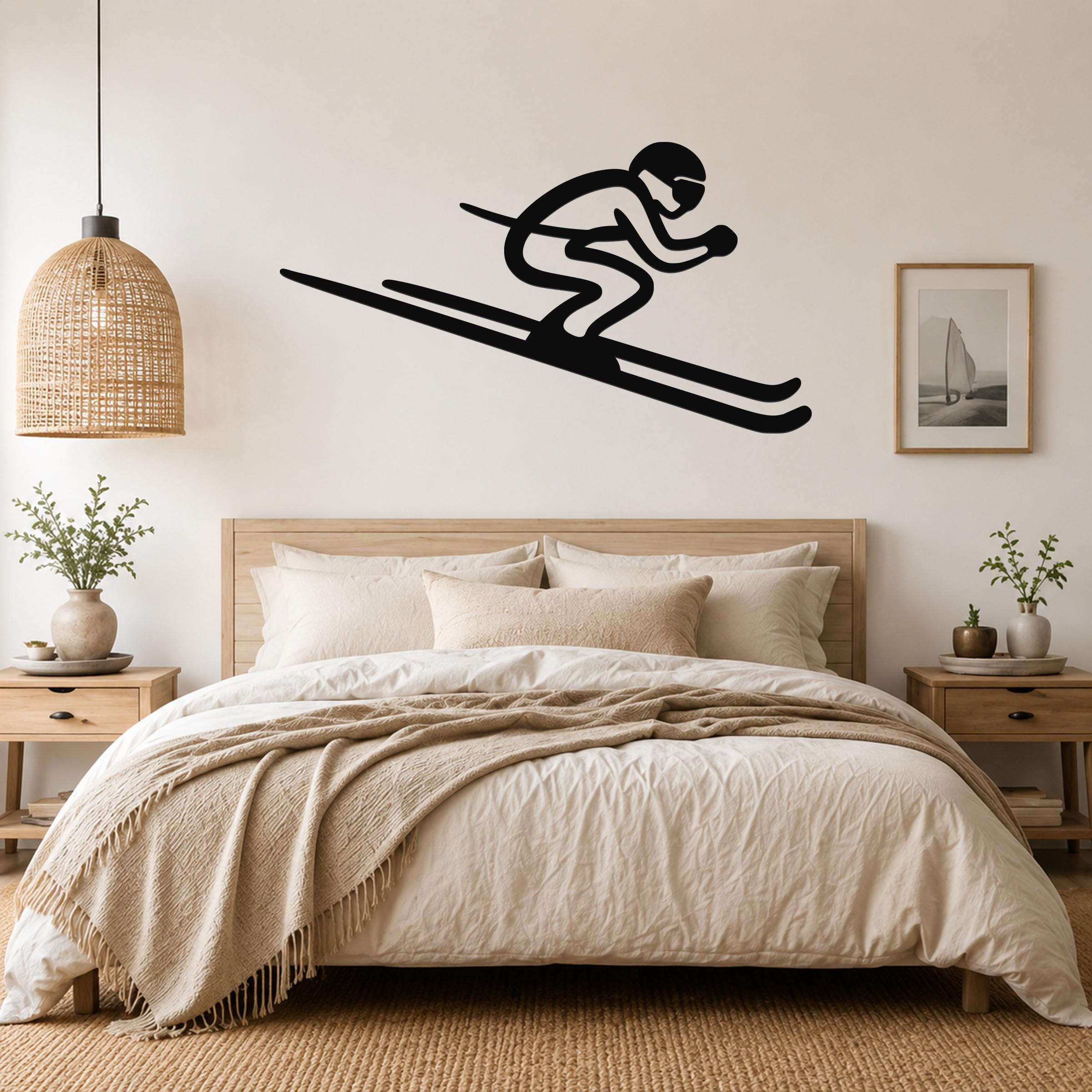 Black metal skier silhouette wall art with motion lines, mounted above a bed in a neutral bedroom.
