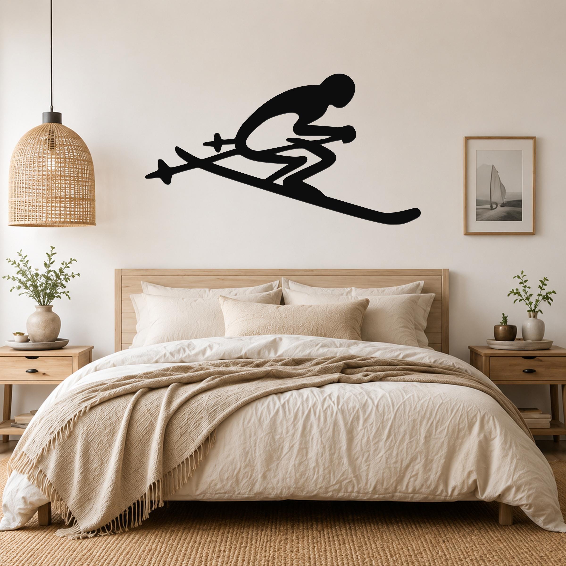 Black metal wall art of a skier silhouette with ski poles, mounted above a bed in a bedroom.
