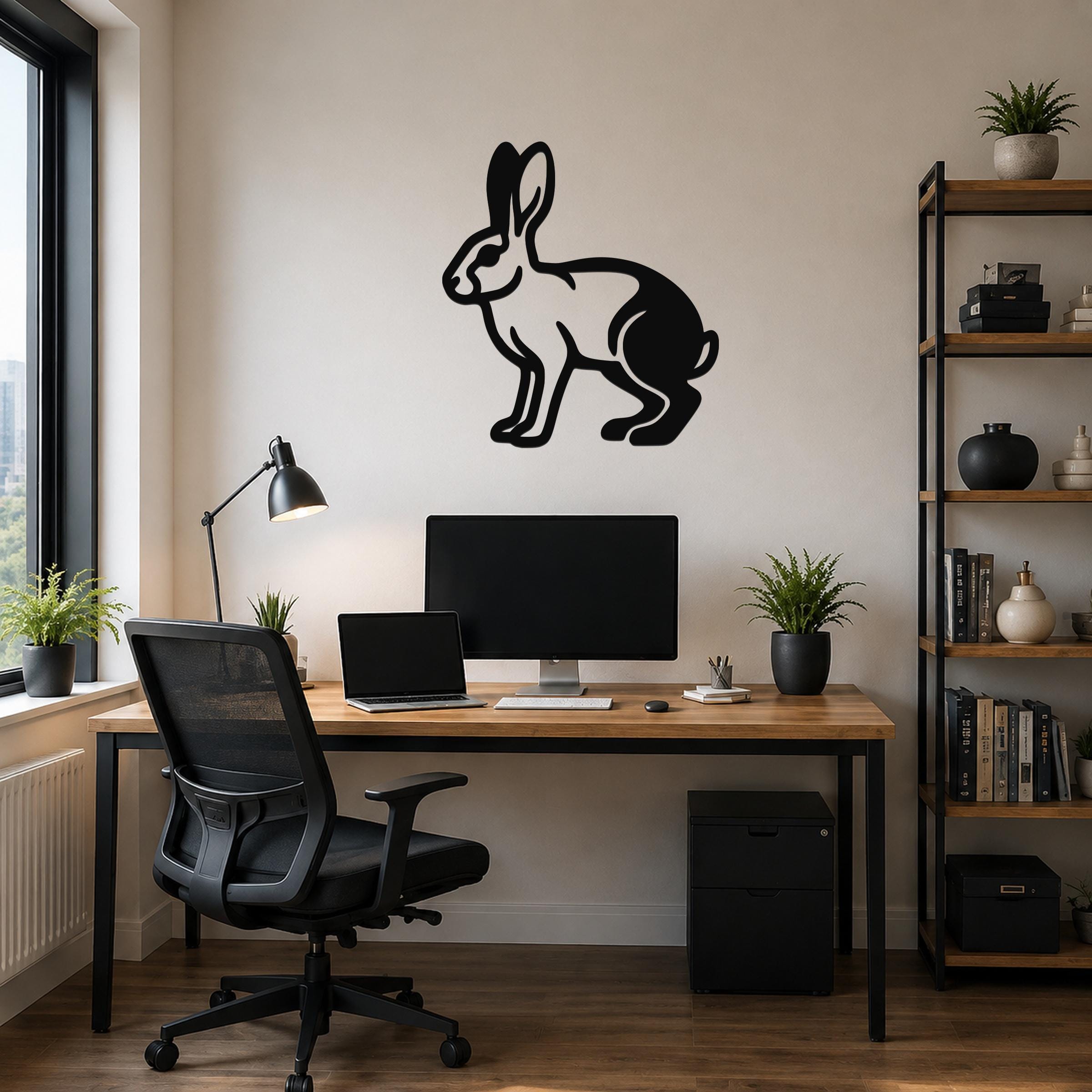 Black metal jackrabbit wall art silhouette mounted above a wooden desk in a modern home office.