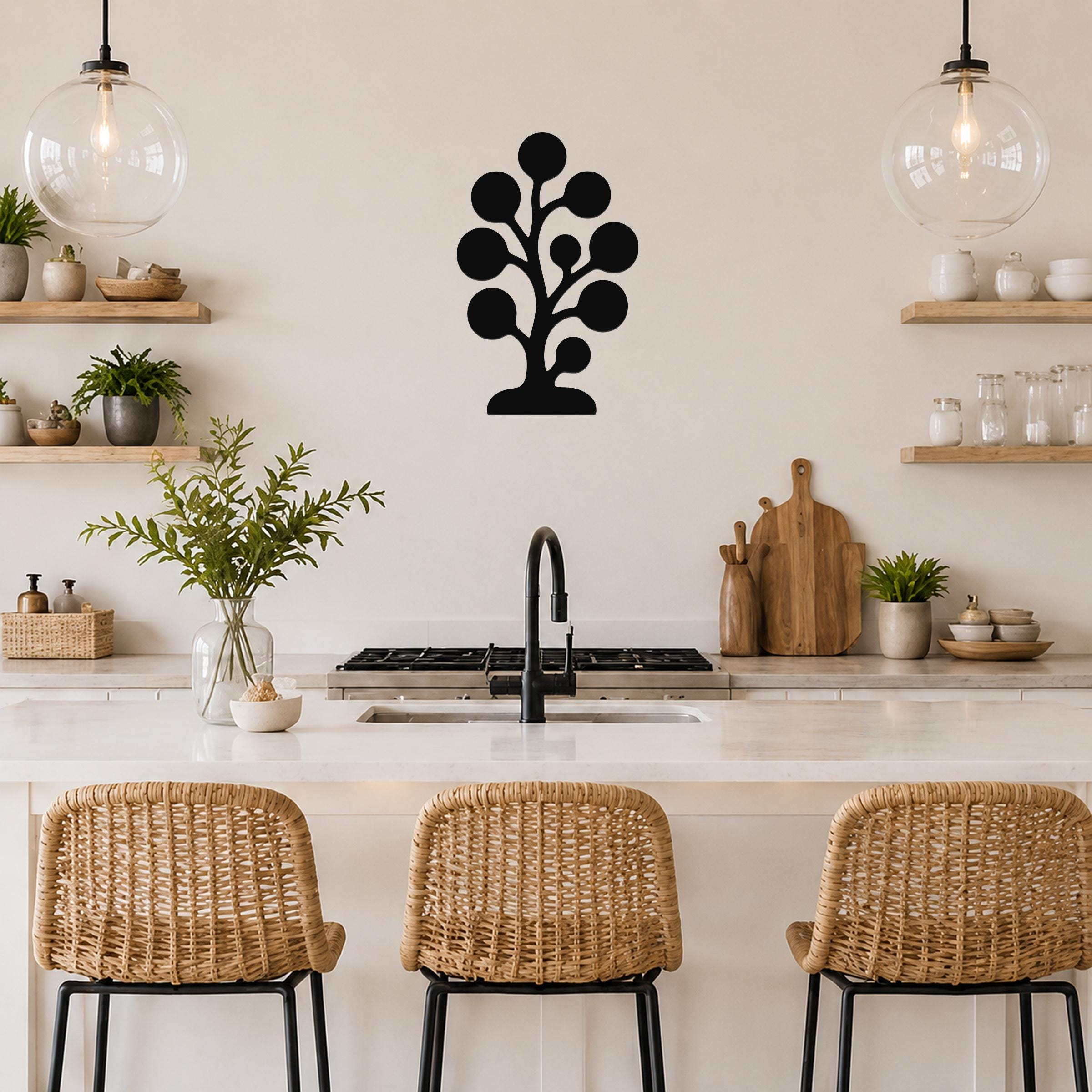 Black metal wall art in a kelp or seaweed silhouette design, mounted on a kitchen wall above a counter with wicker bar stools.