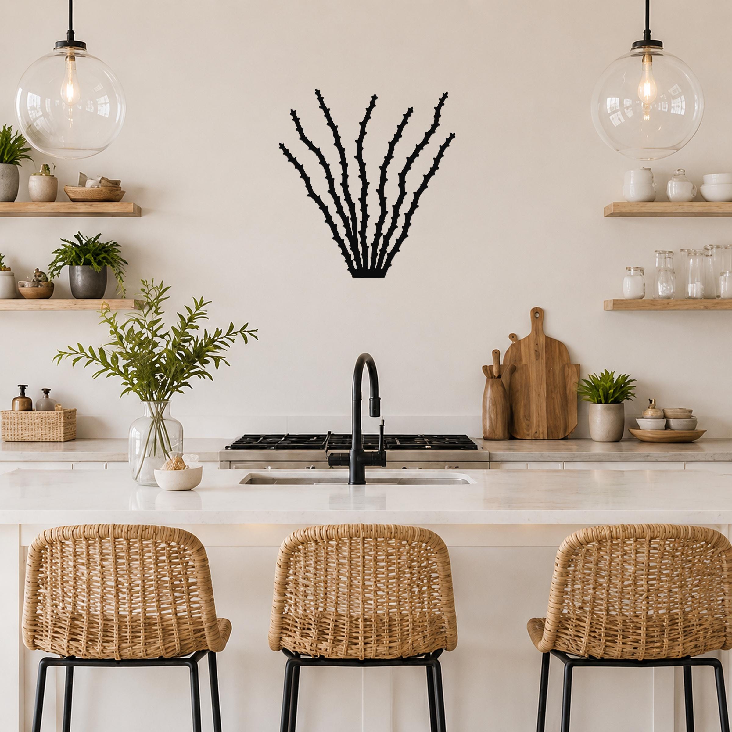 Black metal ocotillo wall art with spiky branch cutouts, mounted on a kitchen wall above a counter.