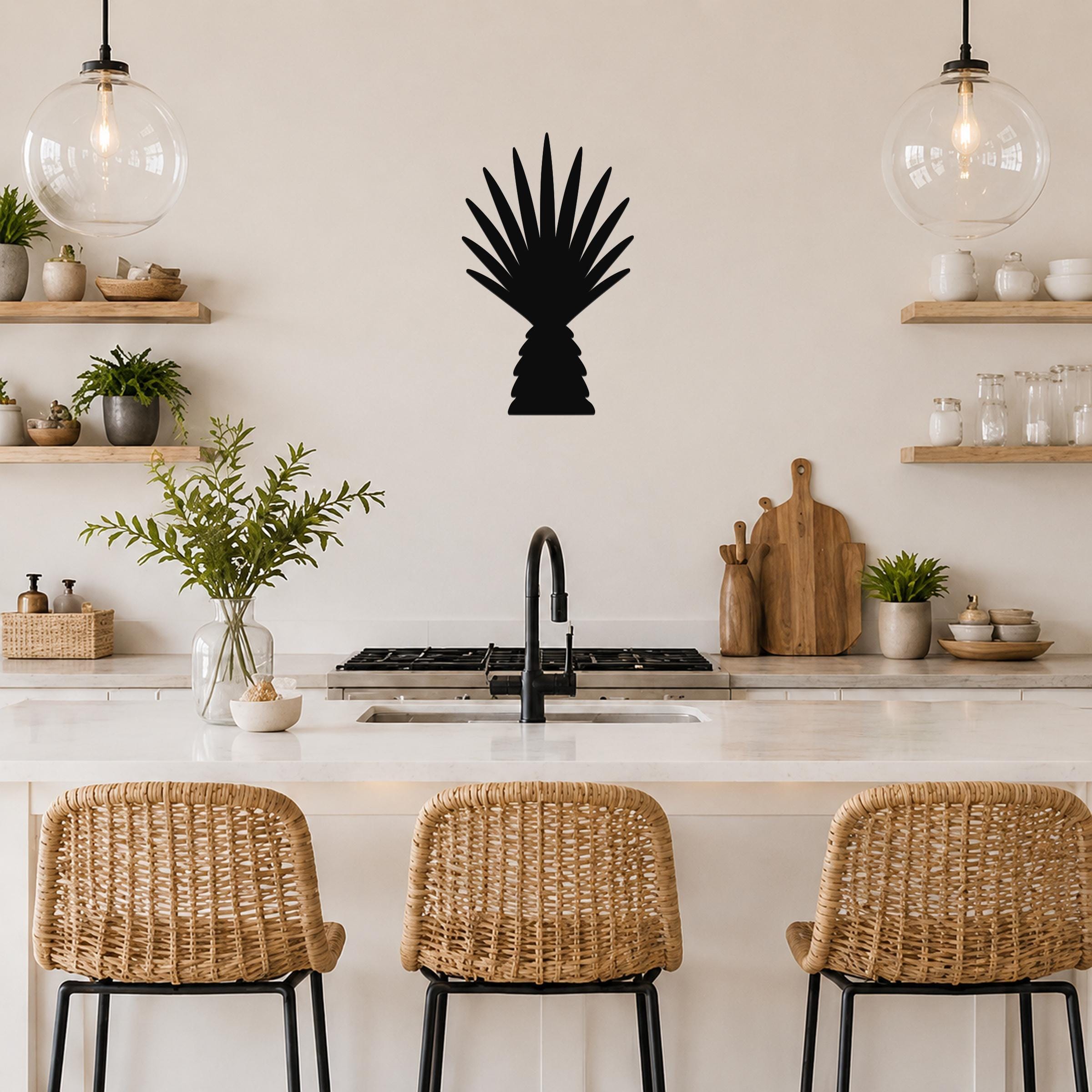 Black metal palm tree wall art with fan-shaped fronds, mounted on a kitchen wall above a counter with wicker bar stools.