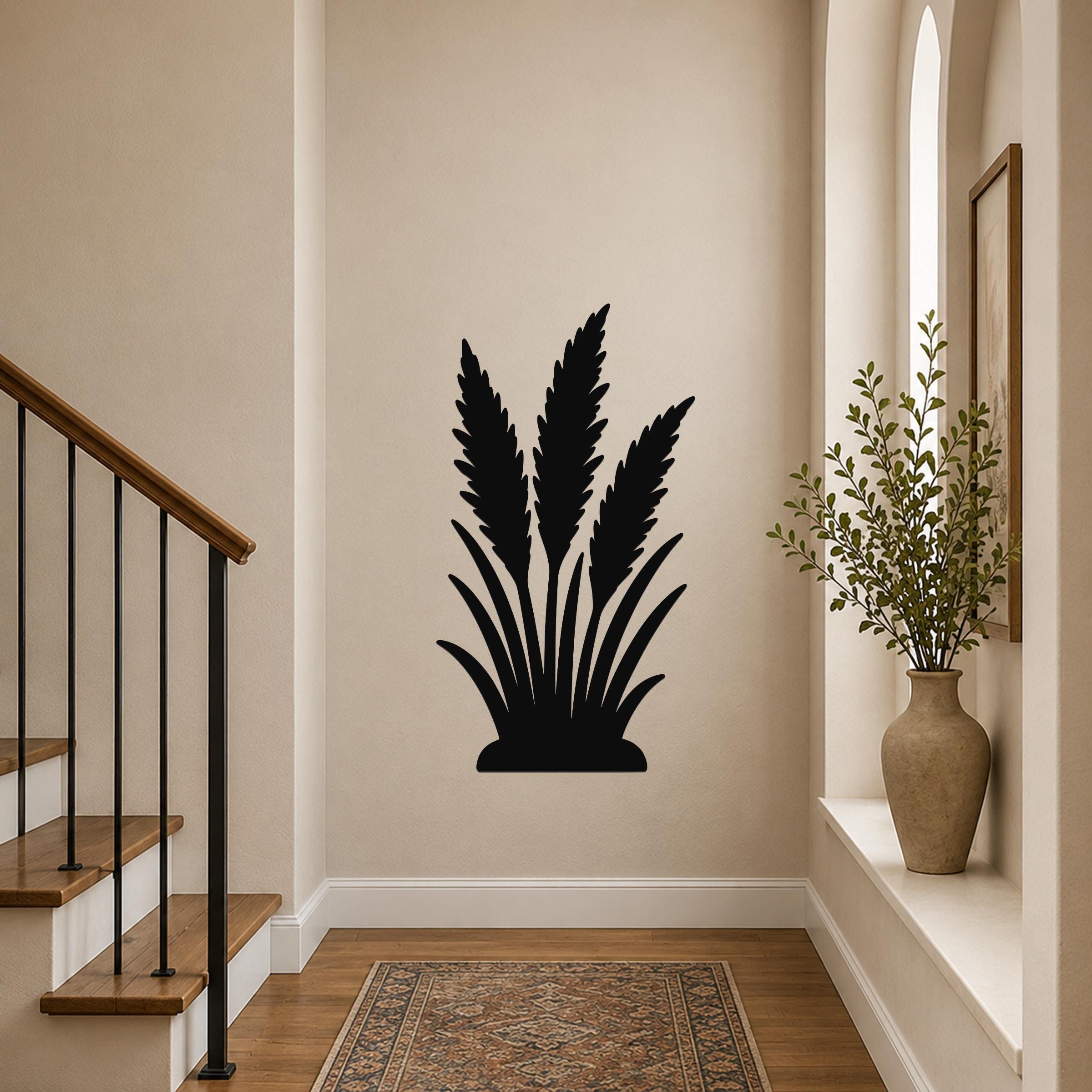 Black metal wall art in a wild grass silhouette design, mounted on a hallway wall above a patterned rug near a staircase.