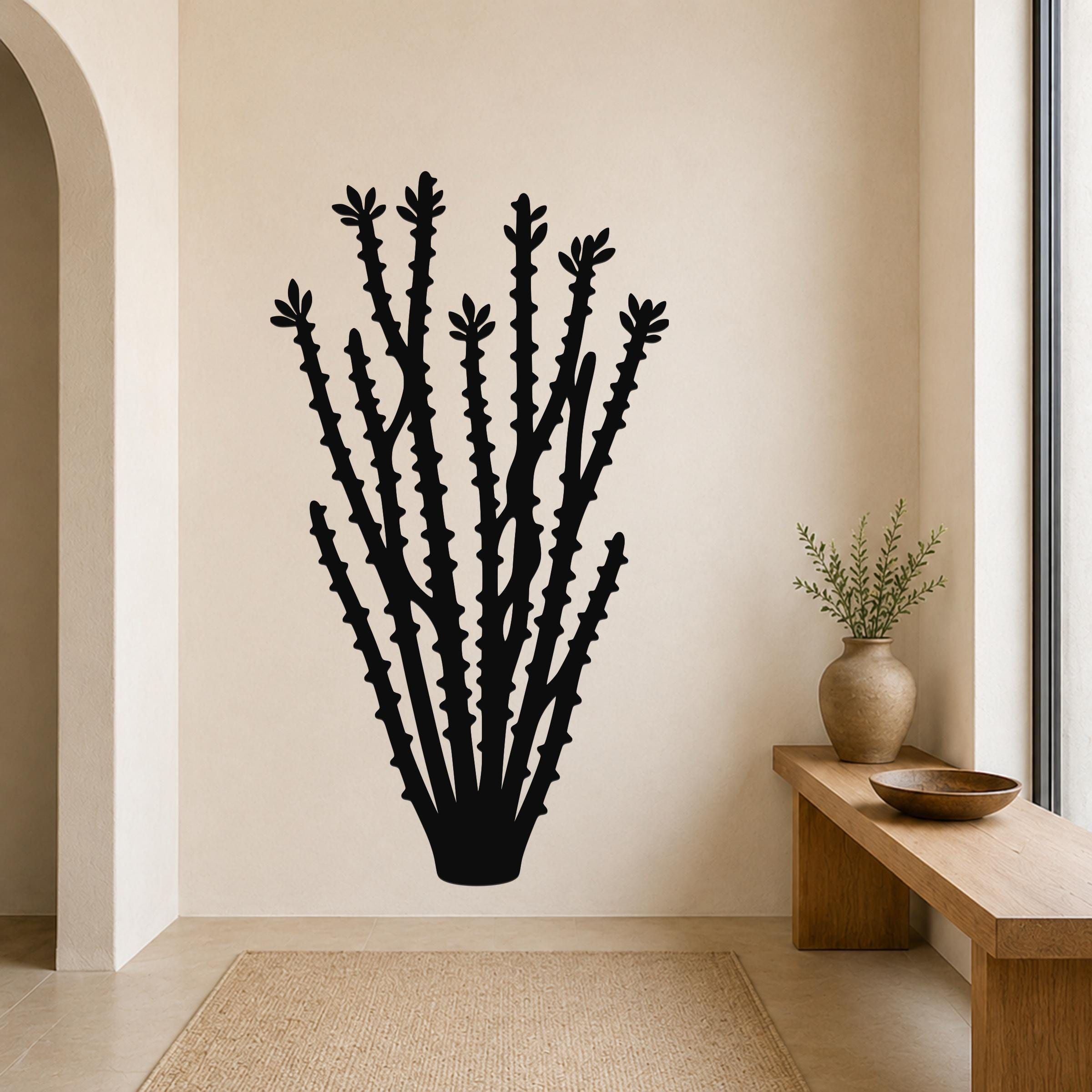 Black metal ocotillo wall art with spiky branch cutouts, mounted on a beige wall above a wooden bench in a neutral entryway.