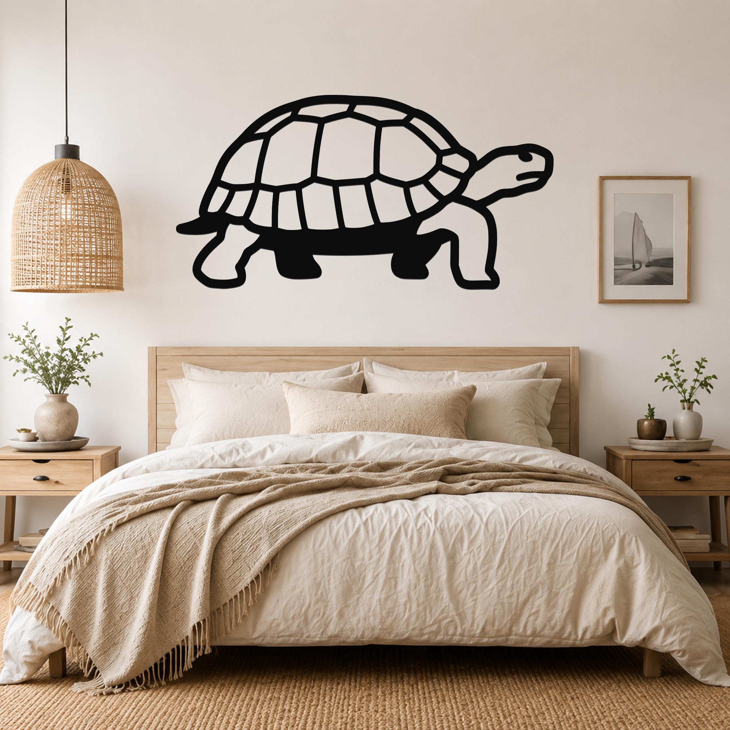 Black metal tortoise wall art with a cutout shell design, mounted above a wooden bed in a neutral bedroom.